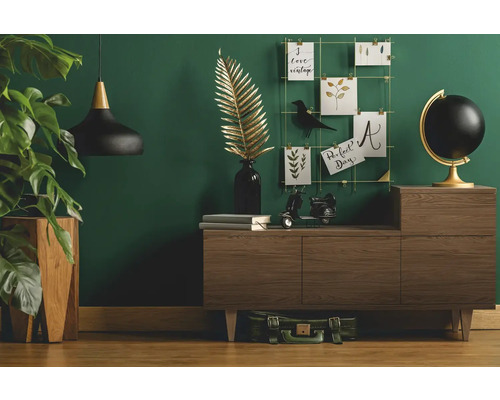 Vardagsrum med byrå, dekoration och krukväxt för en mysig atmosfär