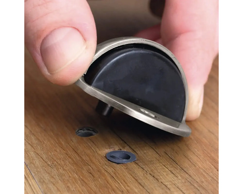 Montering av en dörrstopp på ett trägolv.