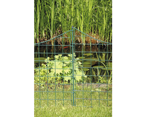 Grönt trädgårdsstängsel av nät framför en damm