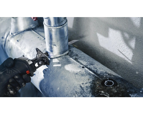 Hantverkare sågar rör med tigersåg.