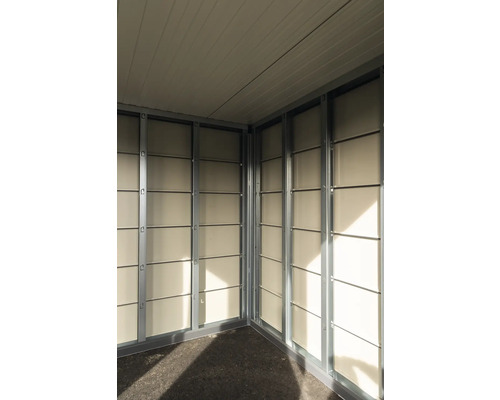 Invändig vy av ett trädgårdshus med metallram och väggpaneler