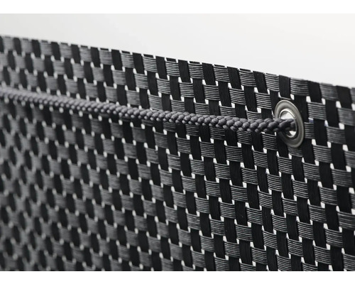 Detaljvy av ett insynsskydd av flätat material med snöre