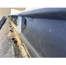 Detaljvy av en takränna med bitumen tätning och avloppsrör