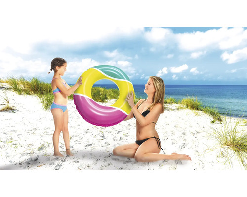 Mor och dotter håller en badring på stranden