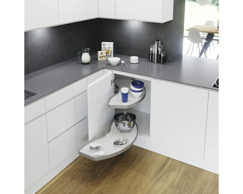 Kökshörn med utdragbar vridplatta för hörnskåp, utrustad med porslin och köksredskap för optimalt utnyttjande av utrymmet.