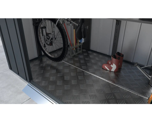 Interiörvy av ett trädgårdsskjul med en cykel, verktyg och stövlar på golvet