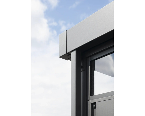 Detaljvy av ett lusthus med fönster och aluminiumram mot en blå himmel