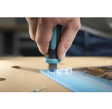 En person gradar en akrylglasplatta med en gradare från Wolfcraft.