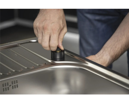 Detaljbild av ett manuellt avloppssystem av metall i en diskho