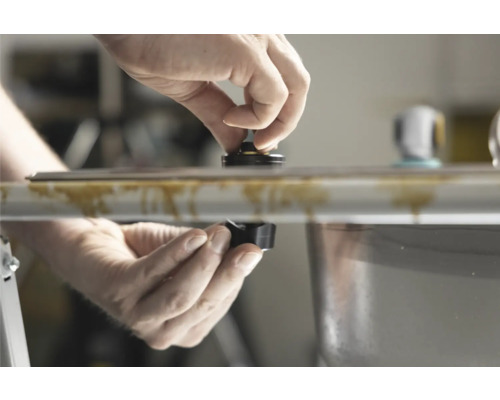 Händer installerar en komponent på ett handfat