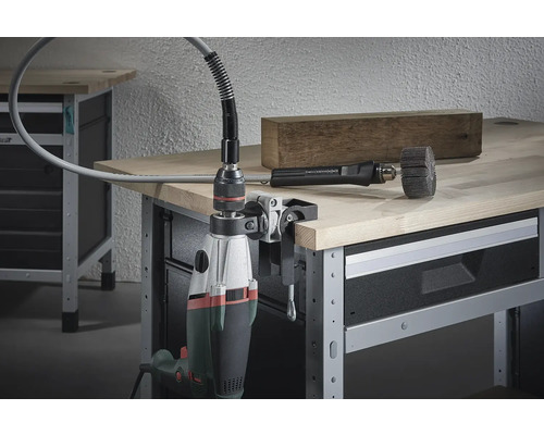 Flexibel axelfäste med borrmaskin fäst på en arbetsbänk, med en träbit och ett borstfäste