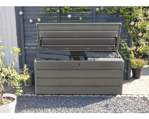 Öppen grå trädgårdslåda med dynor i trädgården