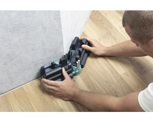 Person använder en geringslåda för att kapa golvlister.