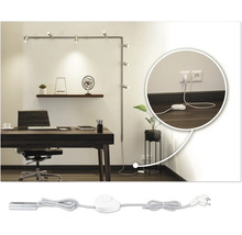 Kontor med skrivbord, kontorsstol, hyllor och en väggmonterad skenspotlight med uttag