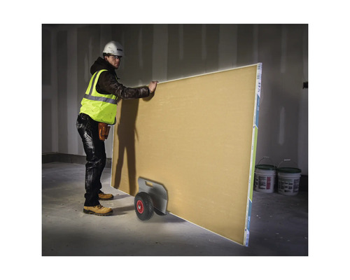 Byggnadsarbetare transporterar gipsskiva med en transportvagn