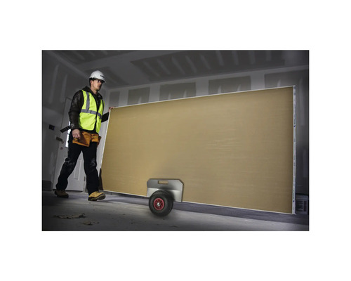 Byggnadsarbetare transporterar en gipsskiva med en transportrulle.