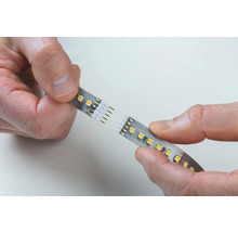 Händer kopplar samman LED-remsa