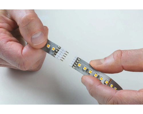 Händer kopplar samman LED-remsa