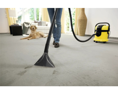 Person som rengör en matta med en mattrengörare i en ljus livsmiljö