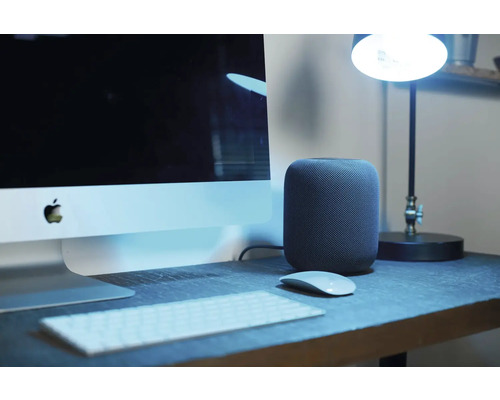 Arbetsplats med dator, tangentbord, mus, högtalare och lampa