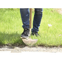 Person som använder en spade i gräset.