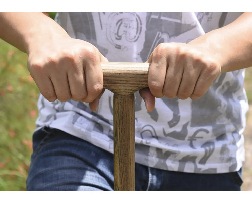 Närbild av en person som håller i ett spadhandtag med trähandtag