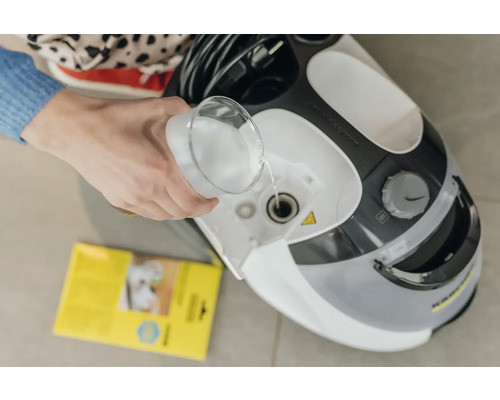 Person fyller vatten i en Kärcher ångrengörare