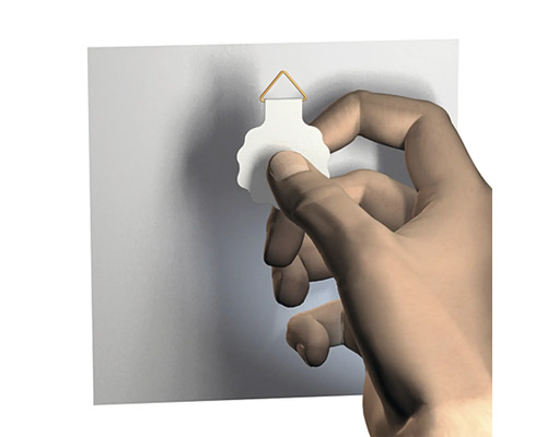 Hand fäster en tavelkrok på väggen