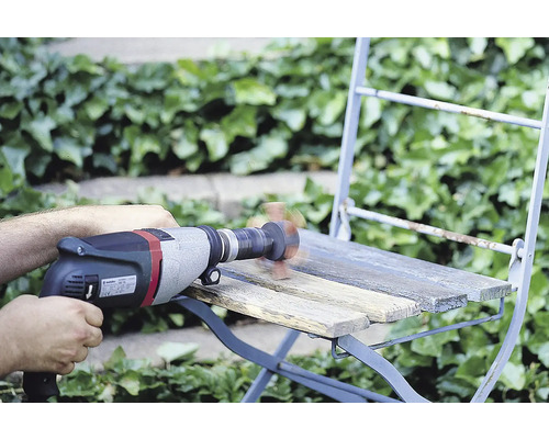 Hantverkare slipar en trästol med en borrmaskin och sliptillsats utomhus.