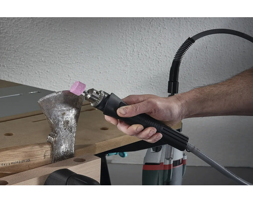 Person slipar yxa med flexibel axel och slipfäste