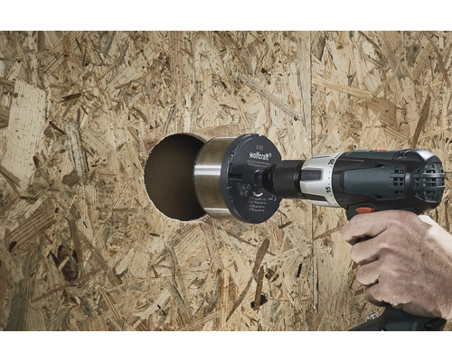 En person borrar ett hål i en träskiva med en hålsåg