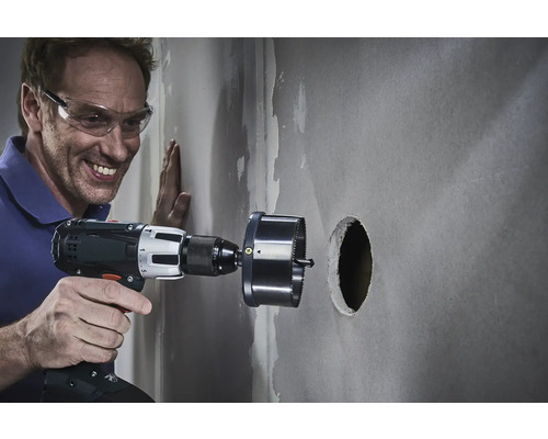 Man borrar ett hål i en vägg med en hålsåg