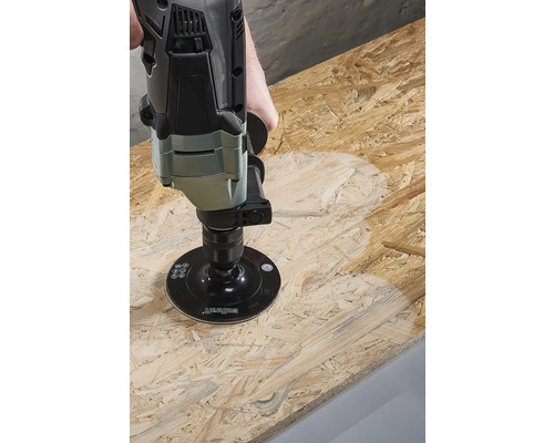 En slipmaskin bearbetar en träskiva.