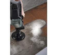 En person slipar en metallyta med en slipmaskin.