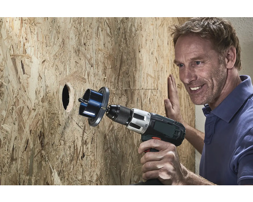 Man borrar ett hål i en trävägg med en hålsåg.