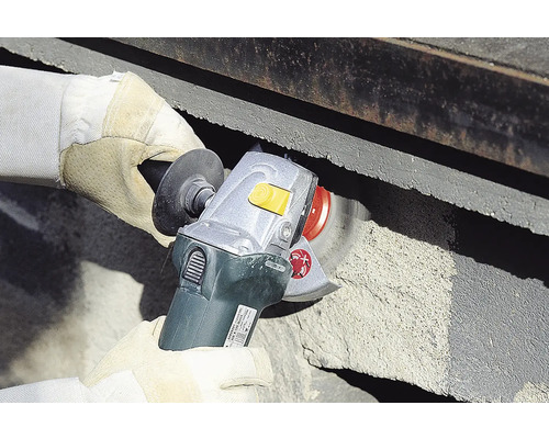 En man använder en slipmaskin för att slipa betong.