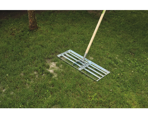 Gräsräfsa med träskaft på gräs