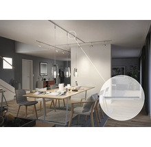 Matsal med matbord och monterat skensystem med spotlights och pendellampor