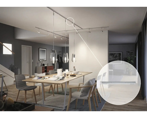 Matsal med matbord och monterat skensystem med spotlights och pendellampor