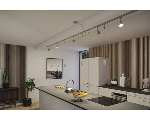 Ljust kök med köksö och skensystem med spotlights och hängande lampor