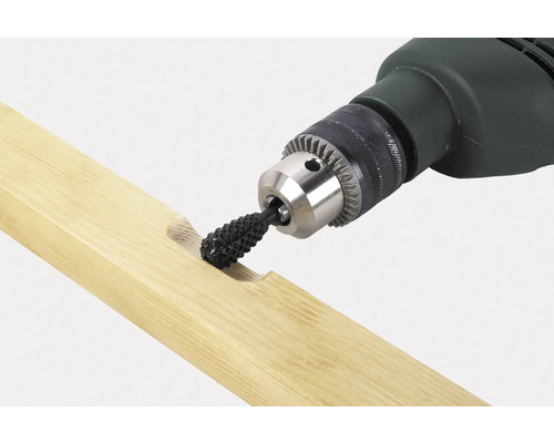 En borrmaskin med en raspinsats bearbetar en träbit.