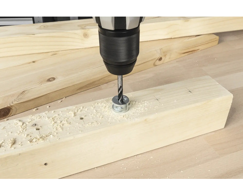 Borrmaskin med forstnerborr som borrar ett hål i en träplanka.