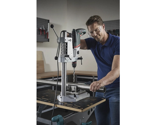 Man borrar ett rör med en bordsborrmaskin på en arbetsbänk