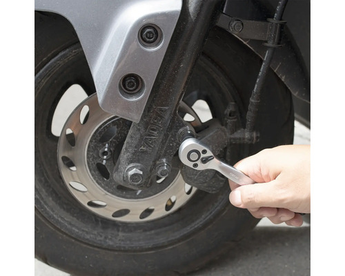 En person använder en spärrnyckel på en motorcykel.