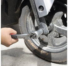 Hand som fäster en spärrnyckel på ett hjul.