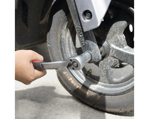 Hand som fäster en spärrnyckel på ett hjul.