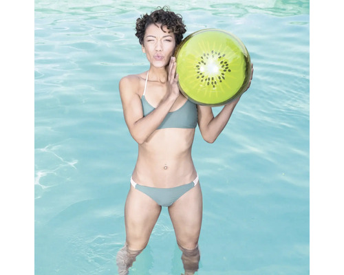 Kvinna i pool håller en uppblåsbar kiwiboll