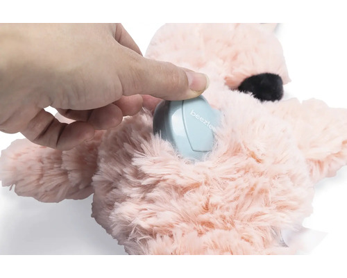 Hand lägger en elektronisk enhet i ett gosedjur