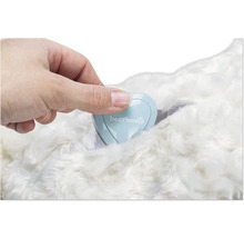 Hand som placerar en hjärtformad behållare med Beeztees logotyp på en päls.