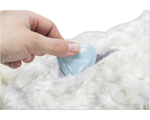 Hand som placerar en hjärtformad behållare med Beeztees logotyp på en päls.